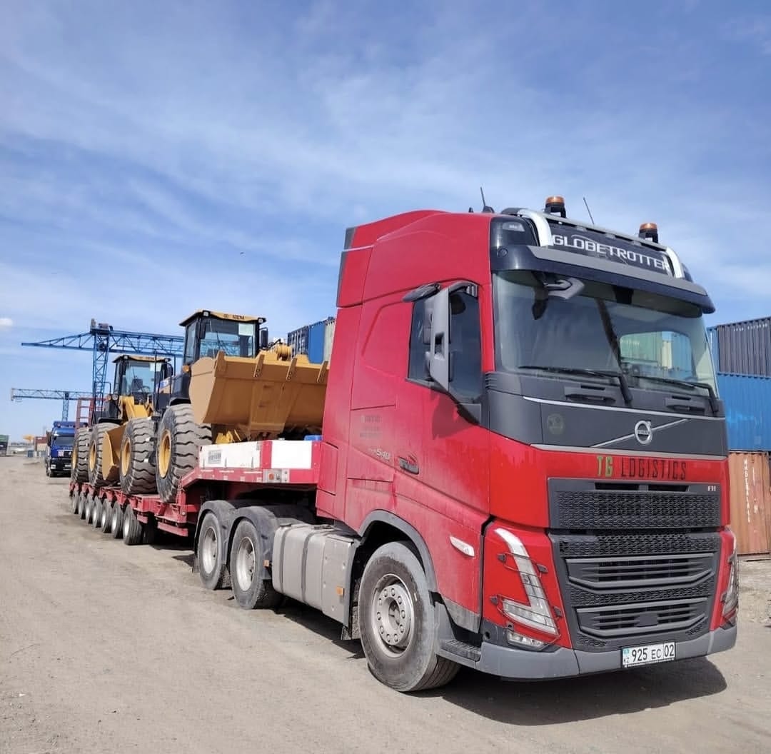 Orange truck transporting large drilling rig on multi-axle trailer