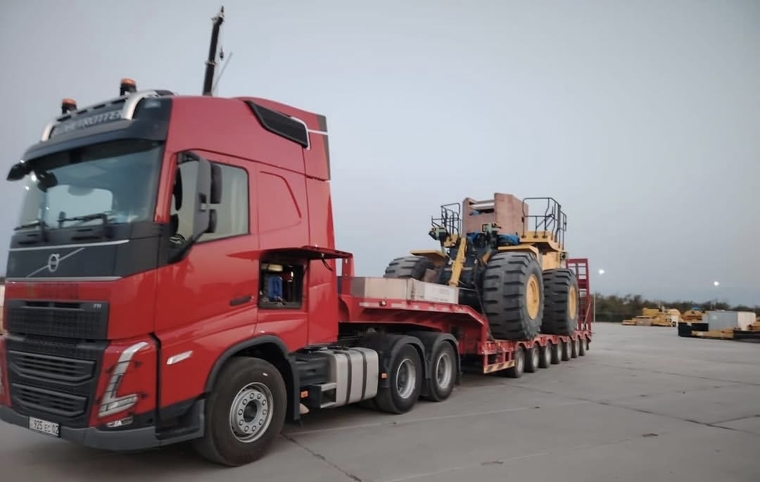 Volvo truck with two yellow wheel loaders at port