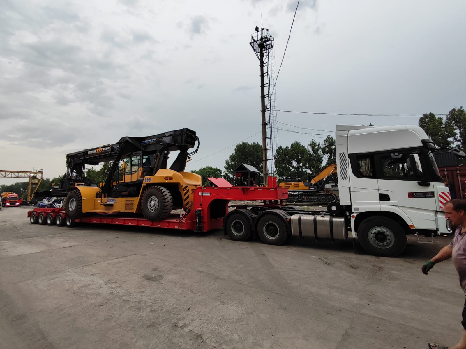 Volvo truck transporting yellow Komatsu wheel loader
